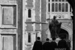 Black and white image of people in robes near a historic court building entrance.