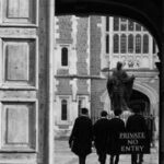 Black and white image of people in robes near a historic court building entrance.