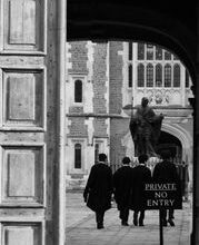 Black and white image of people in robes near a historic court building entrance.