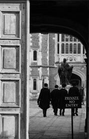 Black and white image of people in robes near a historic court building entrance.